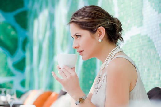 Side profile of a young woman drinking tea