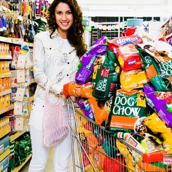 Woman pushing shopping cart loaded with dog foods