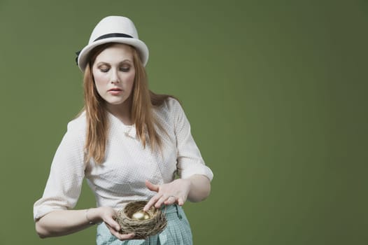 Close_up of a woman showing a golden egg in the nest