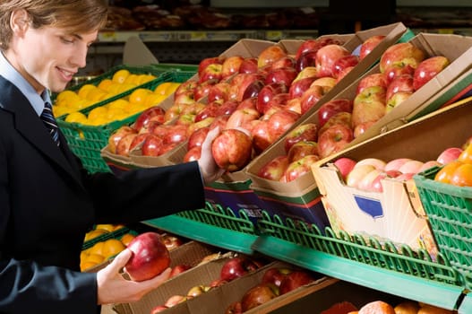 Businessman buying apples in a supermarket