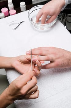 Close_up of a manŽs hand getting manicure