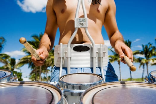 Mid section view of a man playing a drum