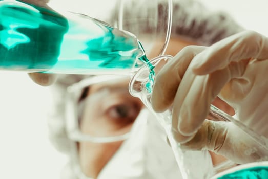 Scientist pouring liquid into a conical flask