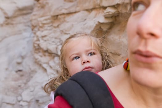 Close_up of a mid adult woman carrying her daughter in a baby carrier