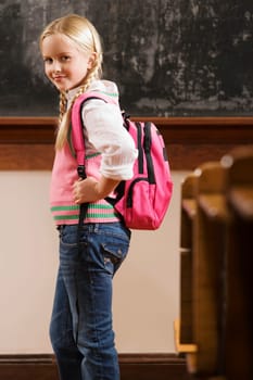 Portrait of a girl standing in a classroom and smiling