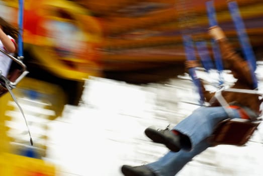 Close_up of a boy and a girl swinging on a chain swing