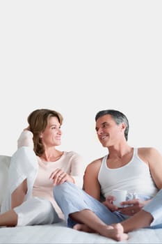 Couple reclining on the bed and talking to each other