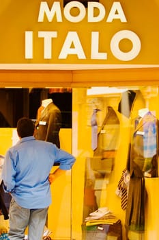 Man looking at the window display at a clothing store, Genoa, Liguria, Italy
