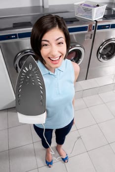 Portrait of a woman holding iron and smiling