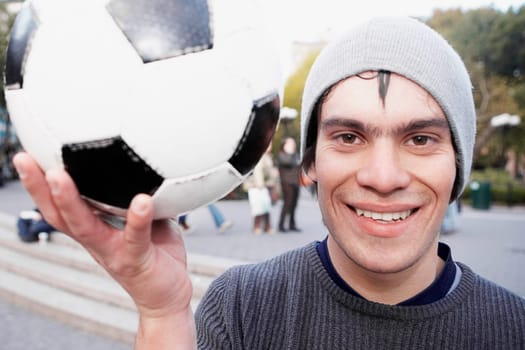 Portrait of a young man holding a soccer ball and smiling