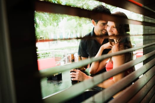 Young couple smiling together at a sidewalk cafe