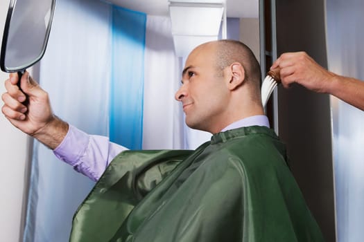 Barber using a brush on a manŽs neck