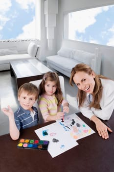 Portrait of a mid adult woman helping her children in painting