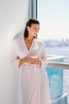 Young woman standing and holding a glass of juice