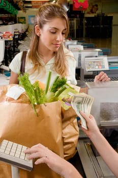 Sales clerk taking money from customer at checkout counter