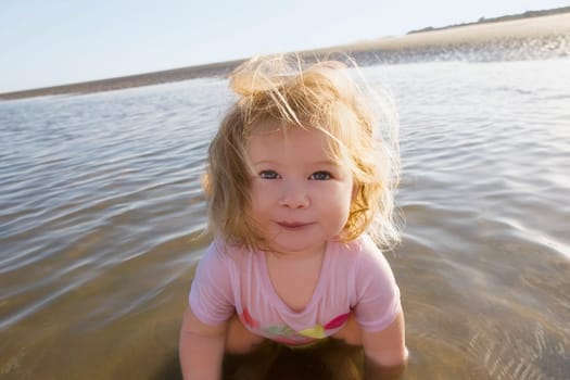 Portrait of a baby girl playing with water and smiling