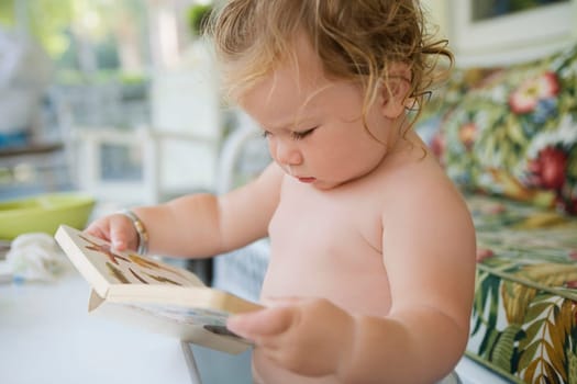 Close_up of a baby girl holding a book