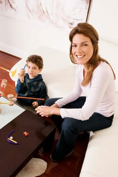 Woman assisting her son in assembling a toy