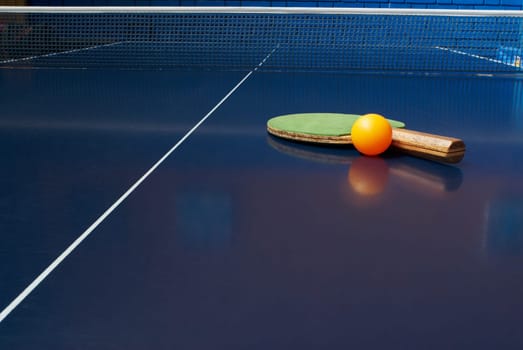 Table tennis racket with a ball on a table tennis table
