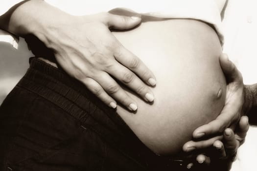 Close_up of a manŽs hand touching the abdomen of a pregnant woman