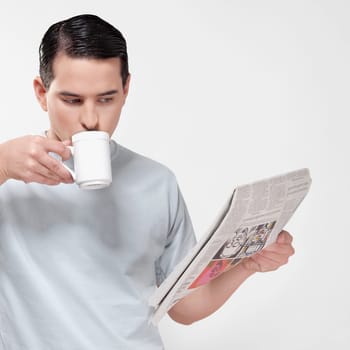 Close_up of a man reading a newspaper and drinking coffee