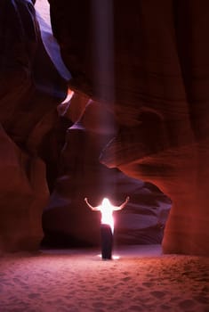 Sunbeam falling on a woman in a canyon, Antelope Canyon, Page, Arizona, USA