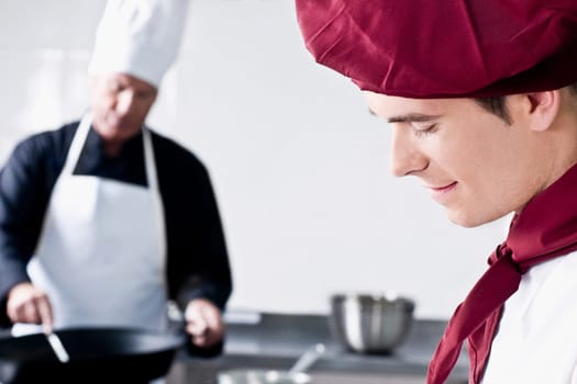 Two chefs cooking food in the kitchen