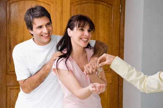 Real estate agent handing house keys to a couple