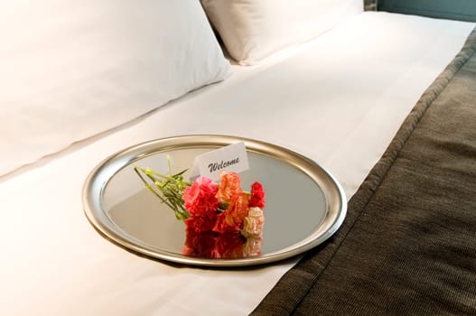 High angle view of flowers with a welcome note in a plate
