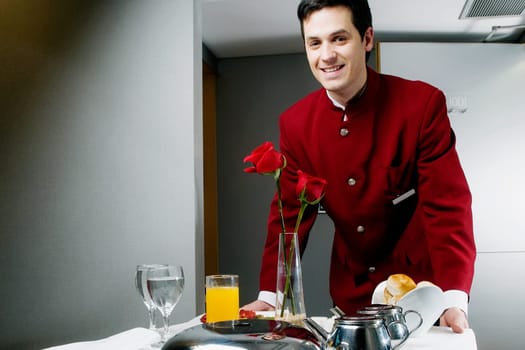 Portrait of a waiter pushing the trolley of breakfast