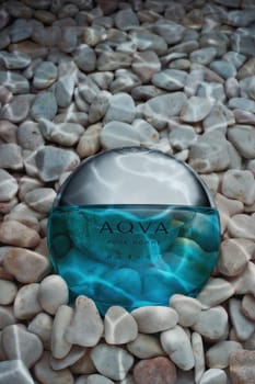 St.Petersburg, Russia - March 2020 - Bottle of cologne Aqva Pour Hoome Marine Bvlgari  on background from light pebbles with drops water.