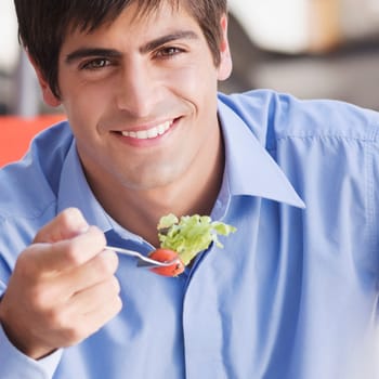 Close_up of a man eating salad in a restaurant