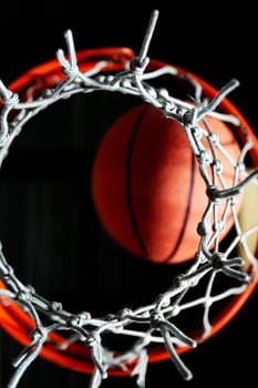 Close_up of a basketball in a hoop