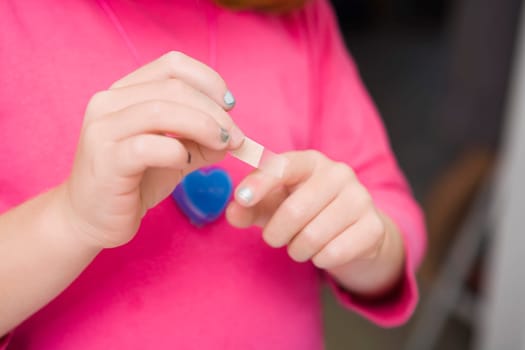 Mid section view of a woman putting a bandage on her finger