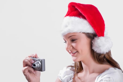 Teenage girl taking picture with a digital camera and smiling