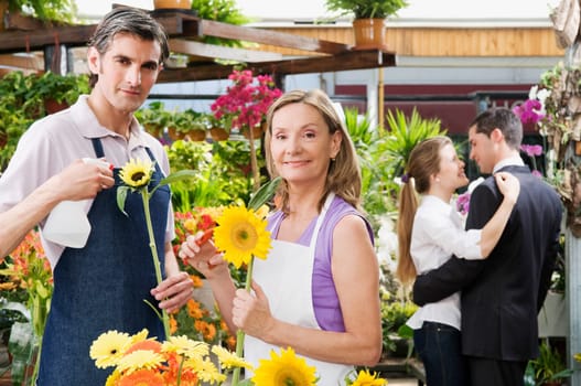 Woman and a man working in a greenhouse