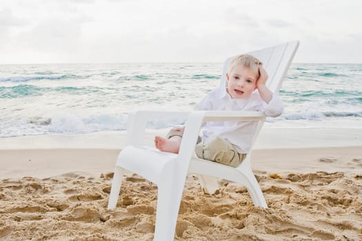 Portrait of a boy sitting on an adirondack chair and smiling
