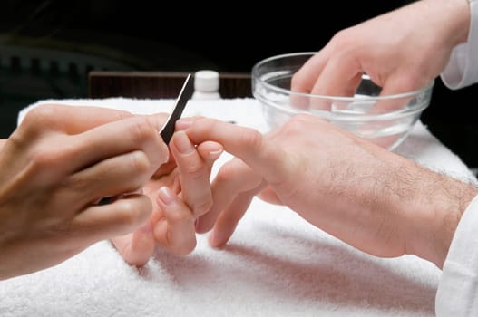 Close_up of a manŽs hand getting manicure