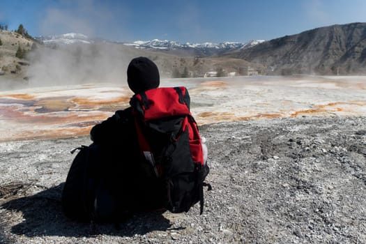 Rear view of a person sitting in front of a hot spring, Mammoth Hot Springs, Yellowstone Lake, Wyoming, USA