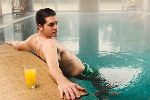 Mid adult man leaning at the poolside