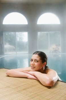 Young woman leaning over the edge of a pool