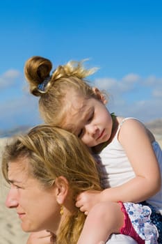 Woman carrying her daughter on her shoulders, Cabo San Lucas, Mexico