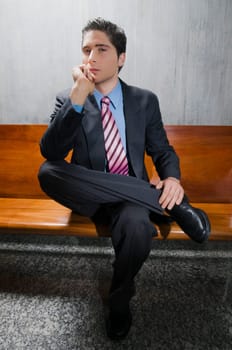 Portrait of a businessman sitting on a bench and thinking