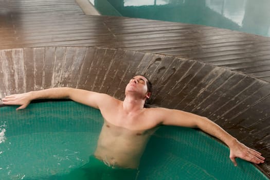 Mid adult man leaning at the poolside