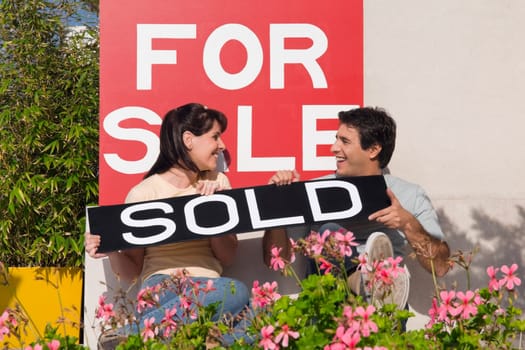 Couple holding an information board and smiling