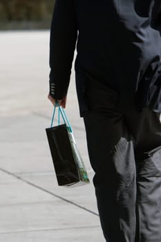 Rear view of a businessman carrying a shopping bag