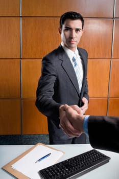 Two businessmen shaking her hands