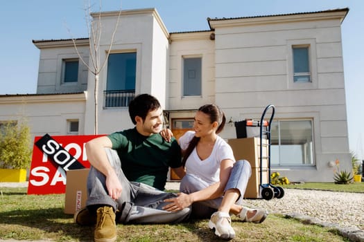 Young couple sitting in front of a sold information board