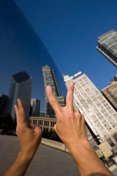 Person showing a peace sign in front of a sculpture, Cloud Gate, Millennium Park, Chicago, Illinois, USA