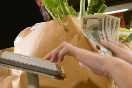 Cashier holding money at a checkout counter in a supermarket